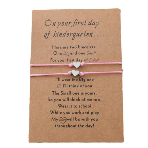 2 pink bracelets with heart charms on brown card for kindy