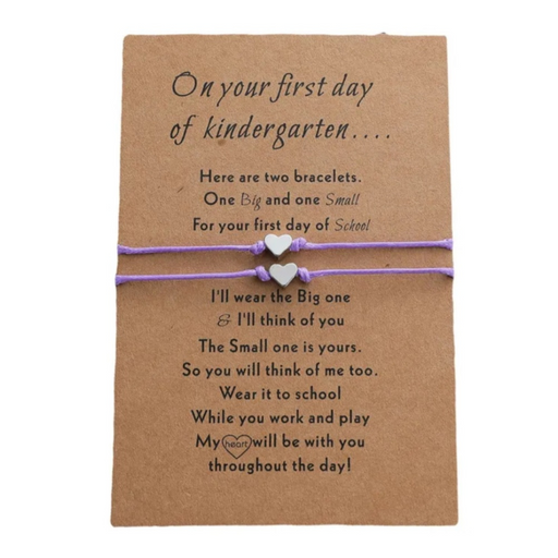 2 purple bracelets with heart charms on a brown message card