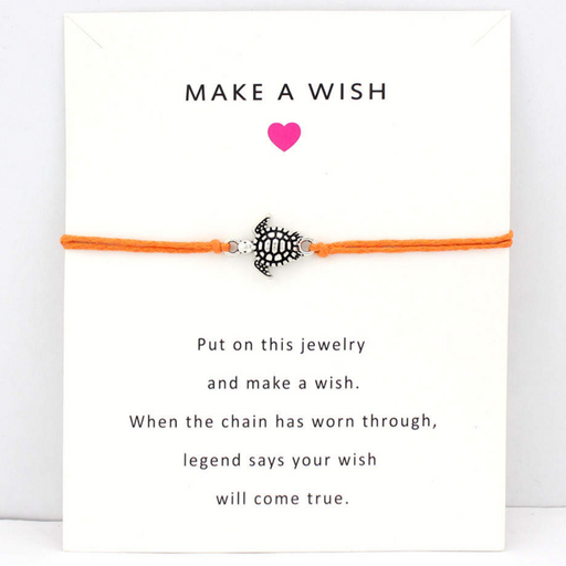 Orange string bracelet with turtle charm on a white message card