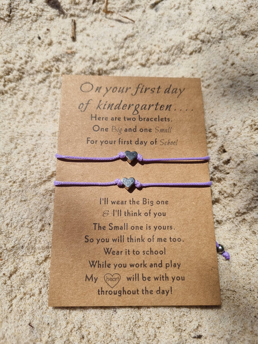 Purple bracelet set of 2 with heart charms on a sandy beach