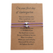 2 purple bracelets with heart charms on a brown message card