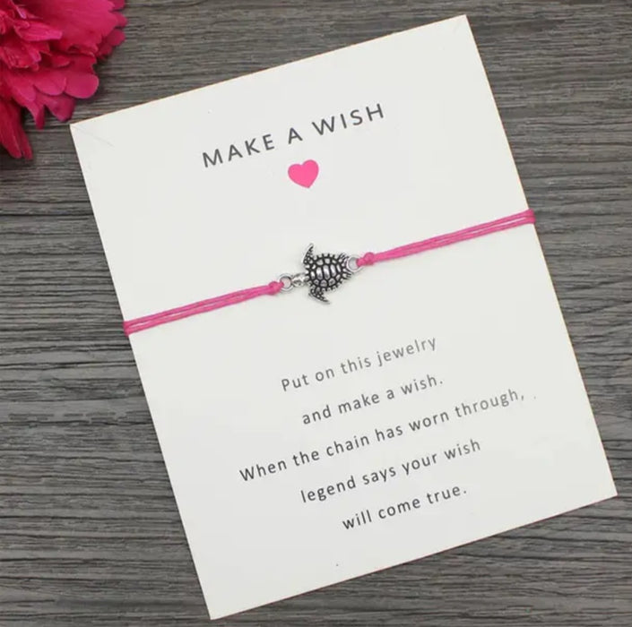 Pink turtle bracelet on a card on table