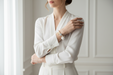 Woman wearing a white suit wearing pom pom bracelet 