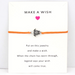 Orange string bracelet with turtle charm on a white message card