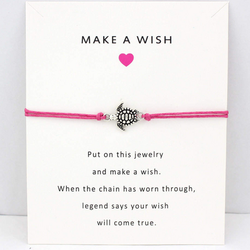 Pink string bracelet with turtle charm on a white message card